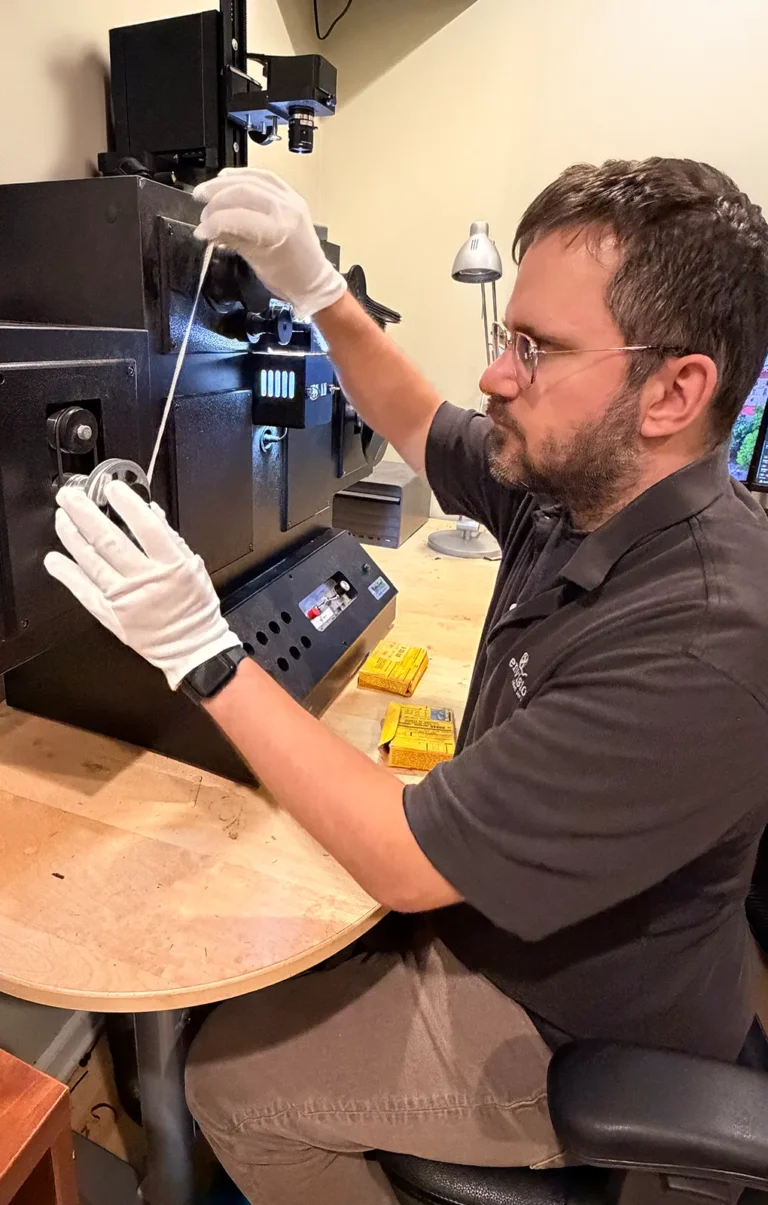 Envision Video Services technician handling motion picture film during professional film transfer