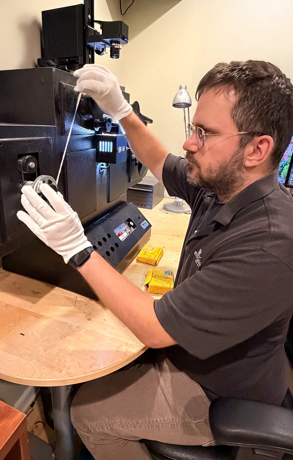 Envision Video Services technician handling motion picture film during professional film transfer